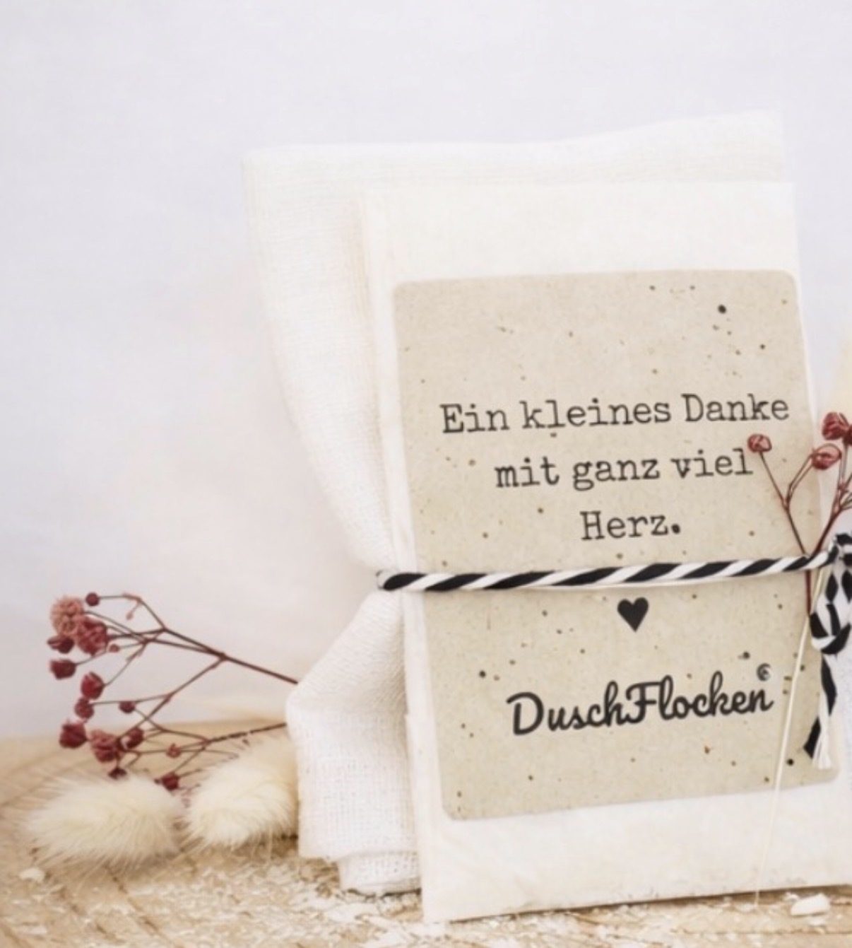 Duschflockenverpackung Ein Karton mit der Aufschrift "Du bist liebenswert!" und einer Blume.